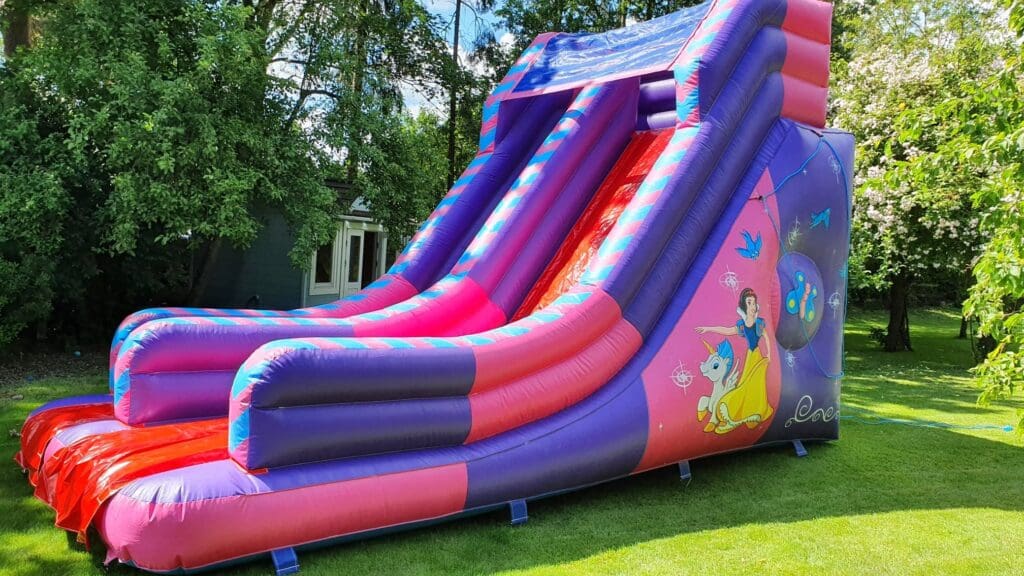 Pink and purple Princess & Unicorn inflatable slide with unicorn and princess artwork, available for hire in Essex.