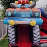 A 3d Monster truck themed bouncy castle with slide