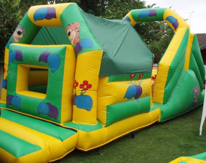 32ft jungle themed inflatable obstacle course with bish and bash section and slide, available to hire in Essex.