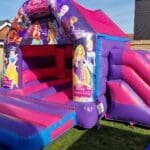 a pink disney themed bouncy castle with slide