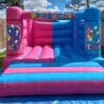 An age specific bouncy castle in a pink and blue 50/50 theme
