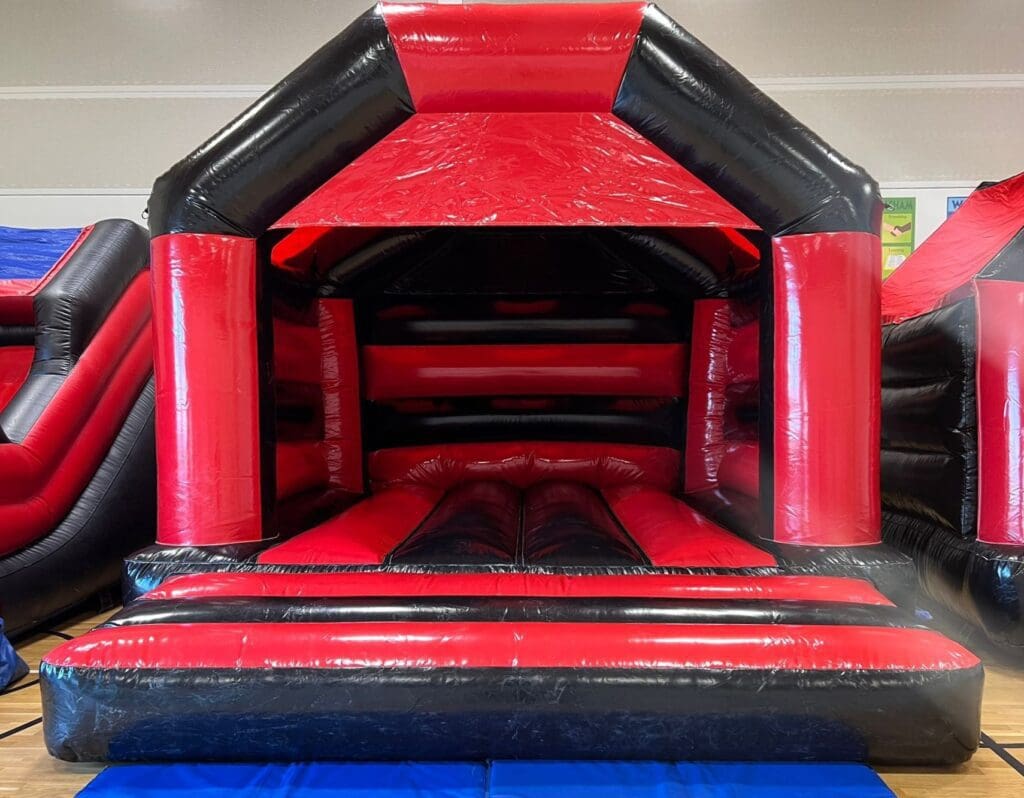 a shiny red and black bouncy castle for children and adults