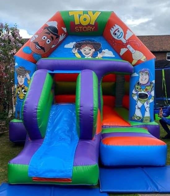 a toy story themed bouncy castle with front facing slide