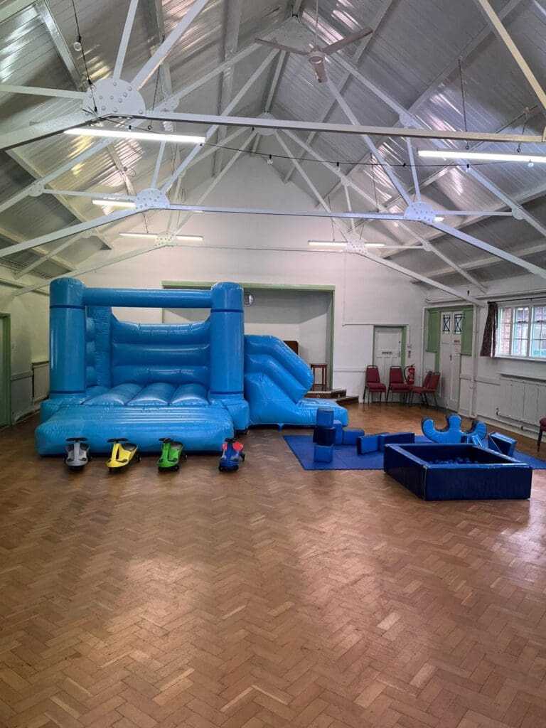 An all blue themed bouncy castle with slide and soft play package