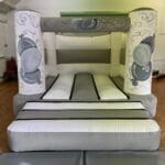 White and silver celebration bouncy castle hire Essex