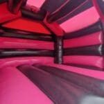 An Adult Pink & Black velcro style bouncy castle inside view